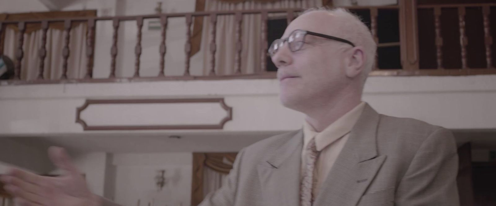 a man in a suit and tie standing in a room