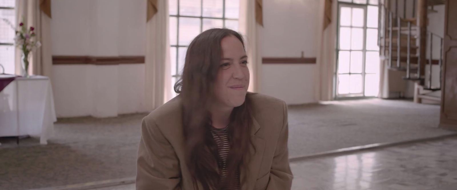 a woman with long hair sitting in a room