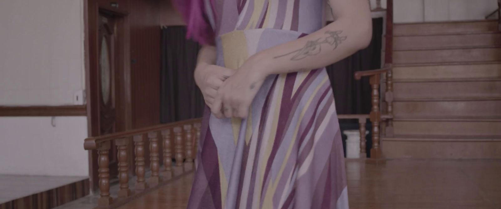 a woman with a tattoo on her arm standing in a room