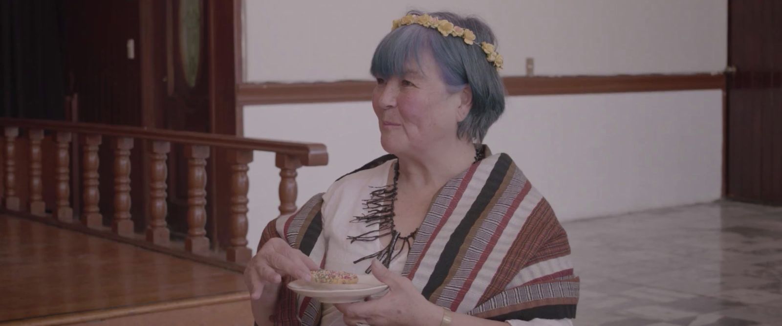 a woman with blue hair holding a plate of food