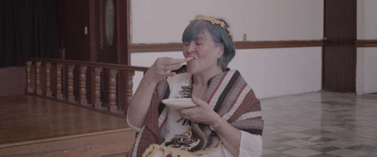 a woman with blue hair eating food from a bowl