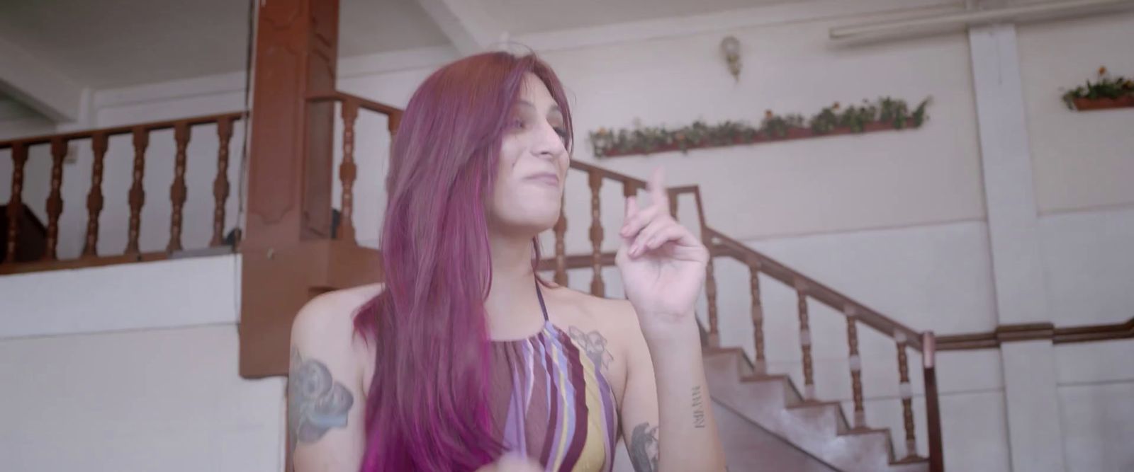 a woman with purple hair smoking a cigarette