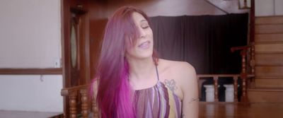 a woman with long purple hair standing in a room