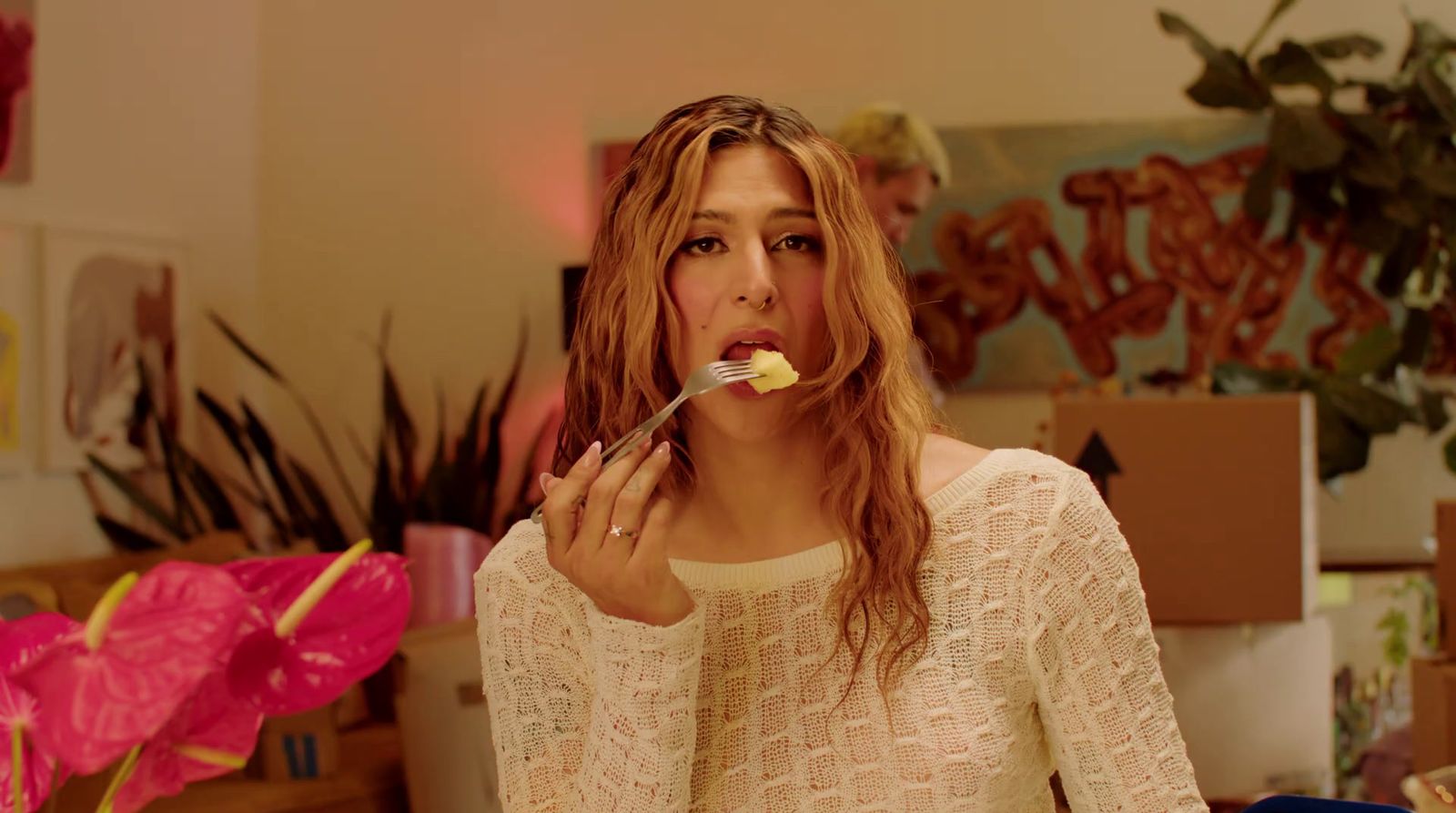 a woman holding a spoon with food in her mouth