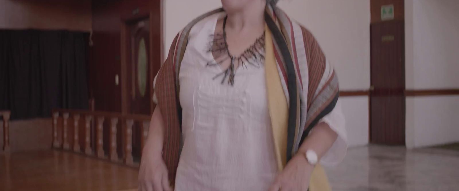 a woman standing in a room with a scarf around her neck