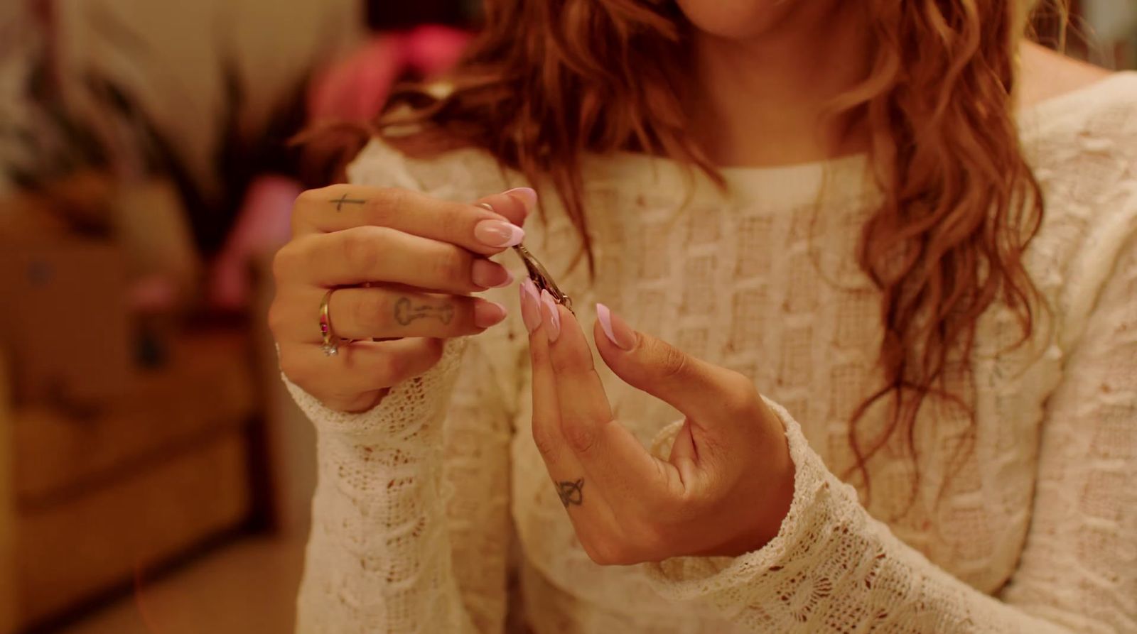 a woman is holding a small piece of jewelry