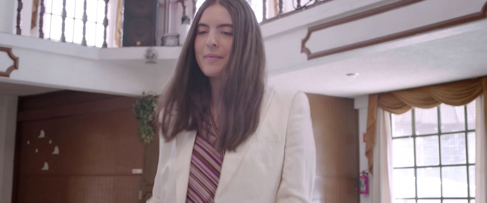 a woman in a suit and tie standing in a room