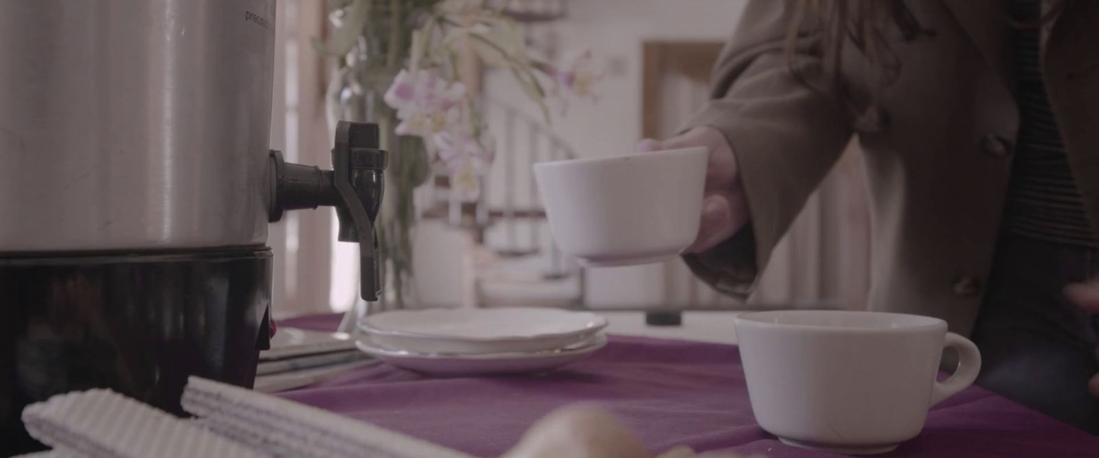 a woman is pouring a cup of coffee