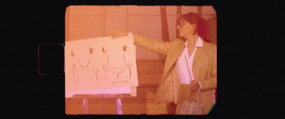 a woman standing next to a white board with writing on it