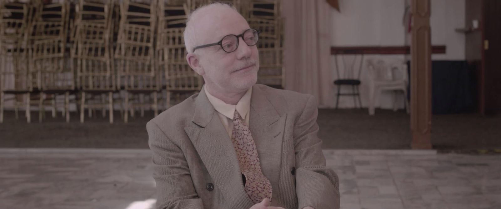 a man in a suit and tie sitting down