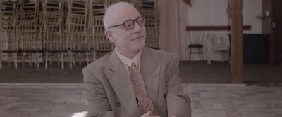 a man in a suit and tie sitting down