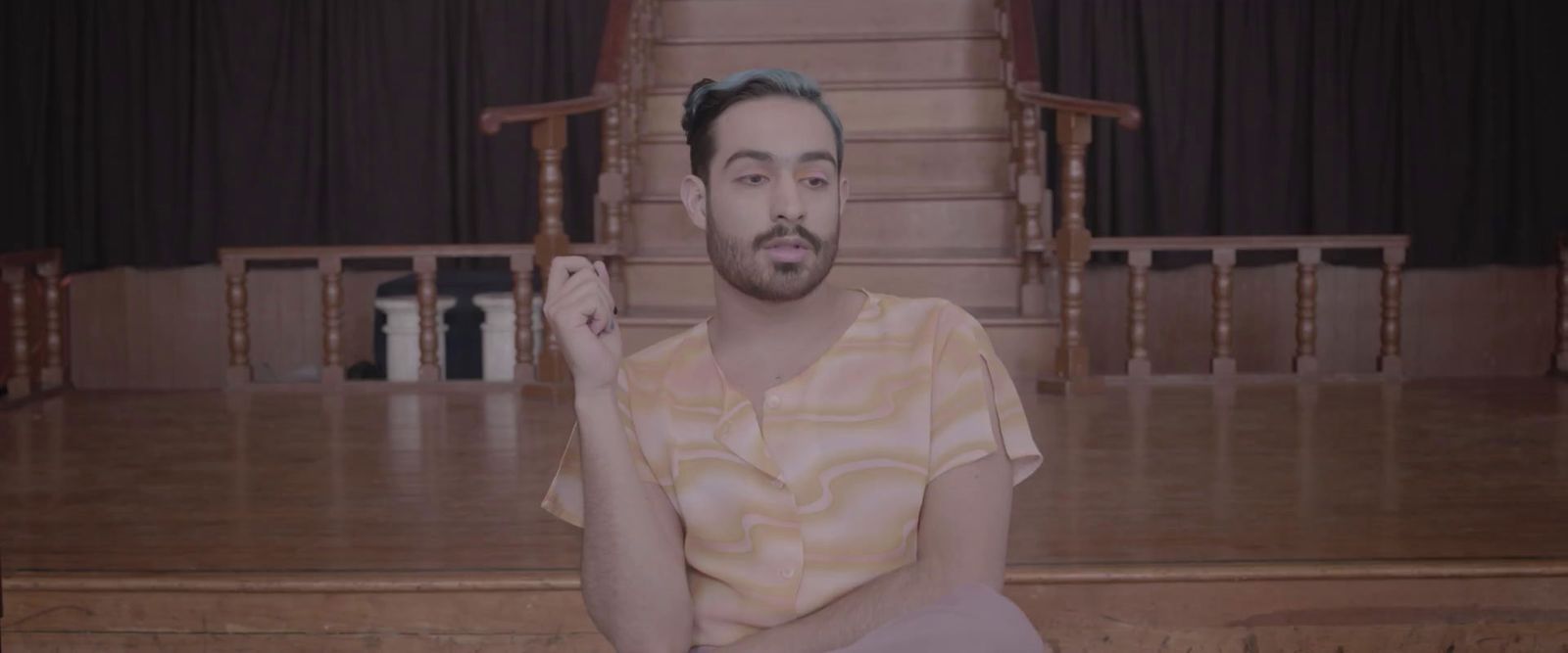 a man sitting on the floor in front of a stage