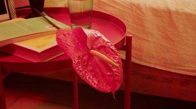 a pink umbrella sitting on top of a red table