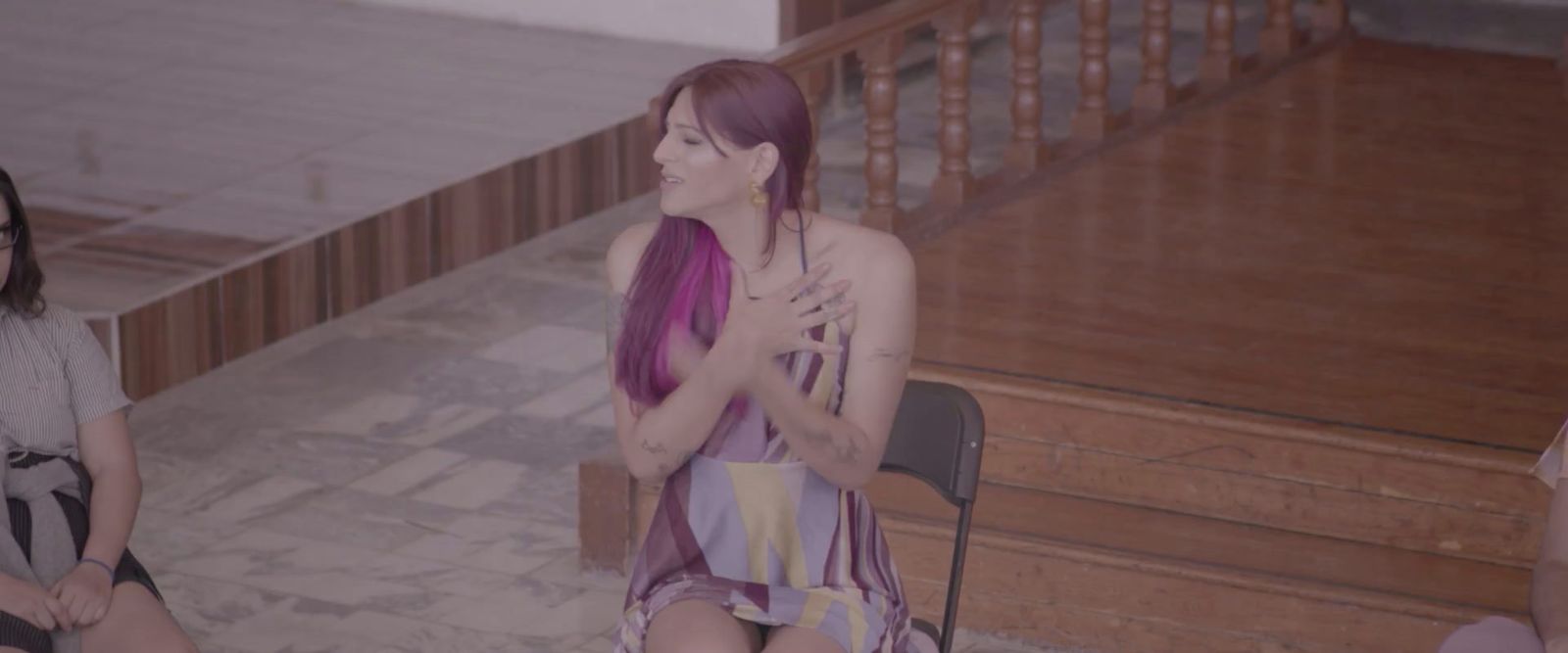 a woman with purple hair sitting on a chair