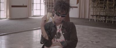 a woman with sunglasses holding a banana in her hand