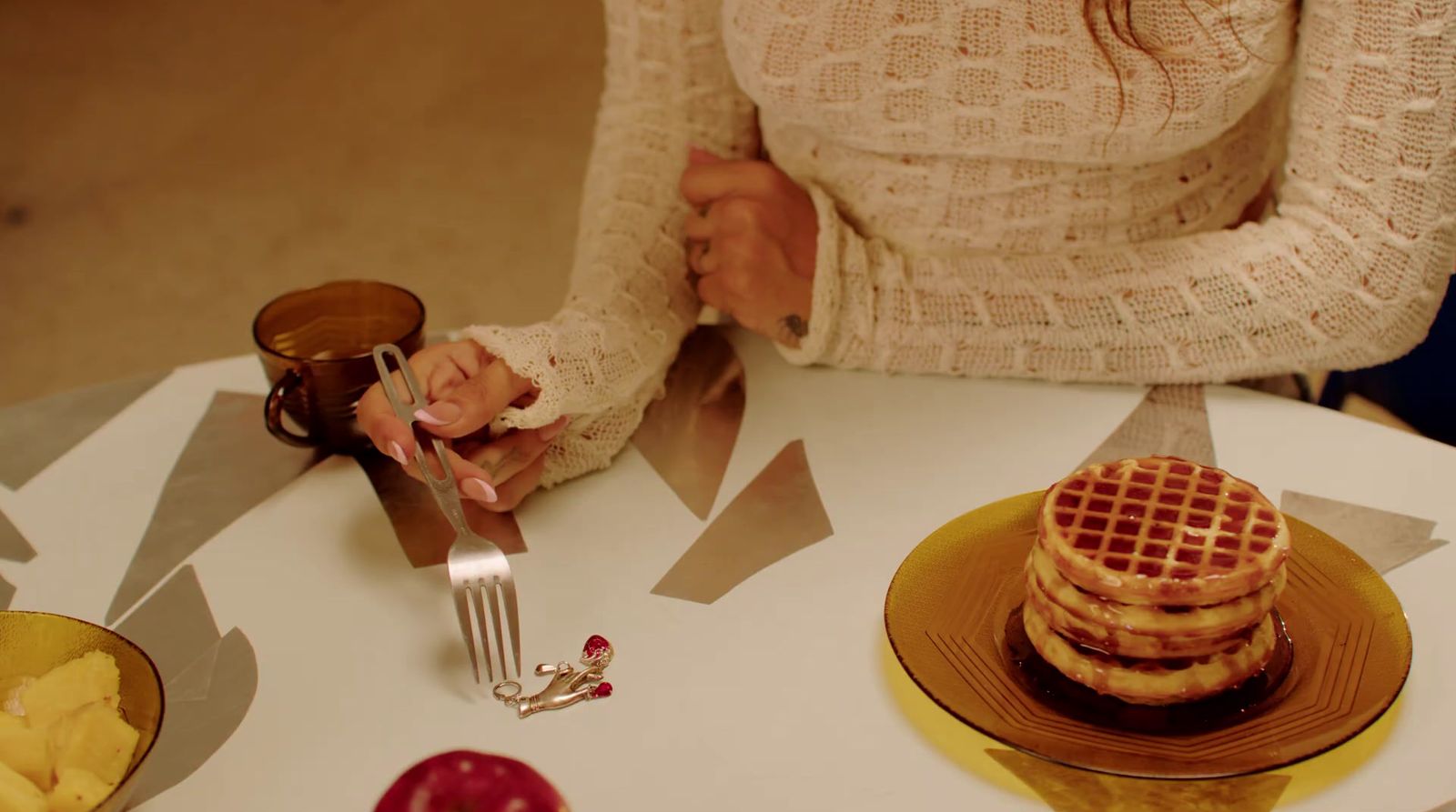 a woman sitting at a table with a stack of pancakes