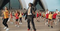 a man in a suit and tie dancing in front of a group of people