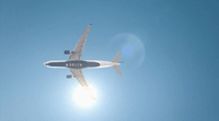 a large jetliner flying through a blue sky