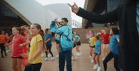 a group of people dancing in front of a building