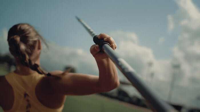 a woman holding a baseball bat on top of a field