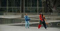 two women walking down a sidewalk in front of a building