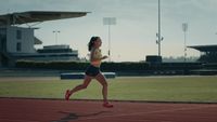 a woman running on a track in a stadium