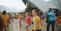 a group of people dancing in front of a building