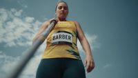 a woman in a yellow shirt holding a baseball bat