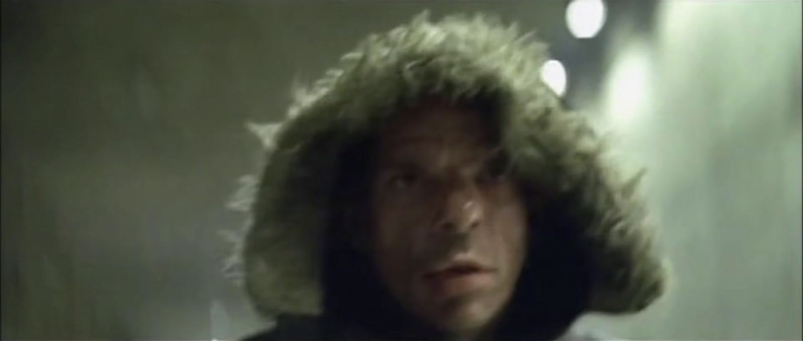 a man wearing a fur hat in a dark room