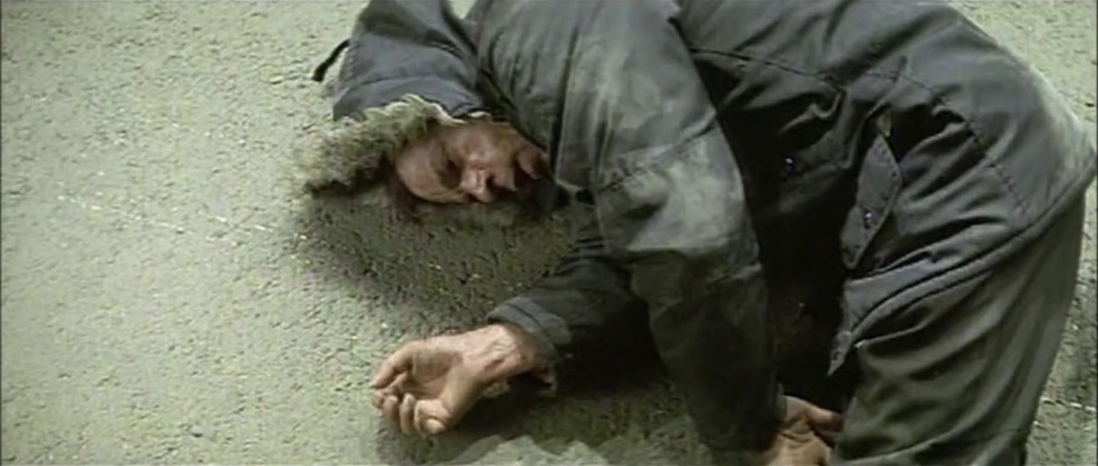 a man laying on the ground with his head down