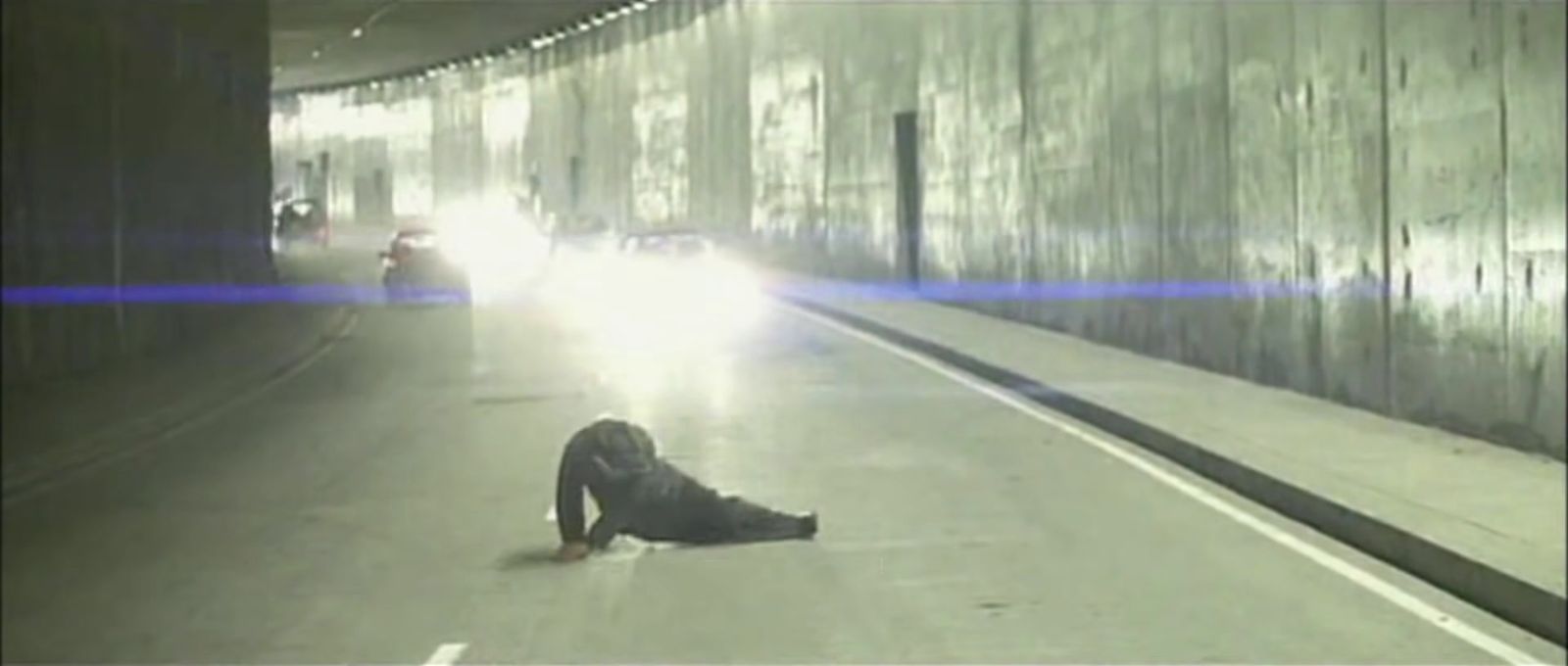 a person laying on the ground in a tunnel