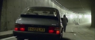 a man standing next to a car in a tunnel