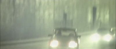 a car driving down a road in the rain