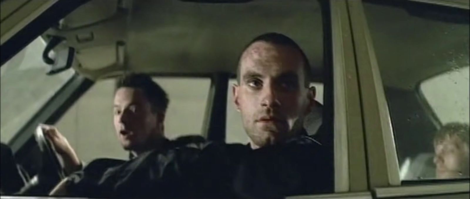 a man driving a car with another man in the passenger seat