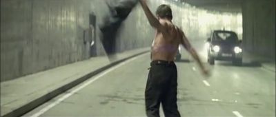 a shirtless man holding a baseball bat in a tunnel