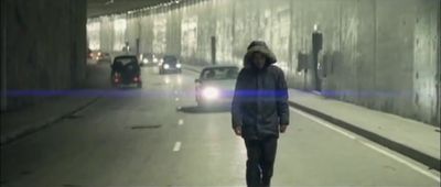 a man walking down a street in a tunnel