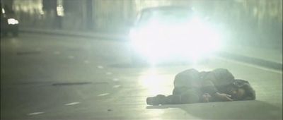 a person laying on the ground next to a car