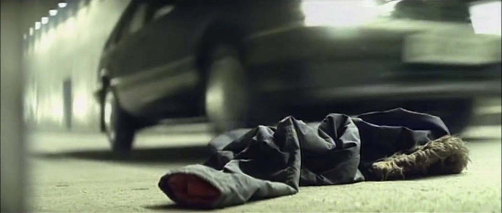 a piece of cloth laying on the ground next to a car