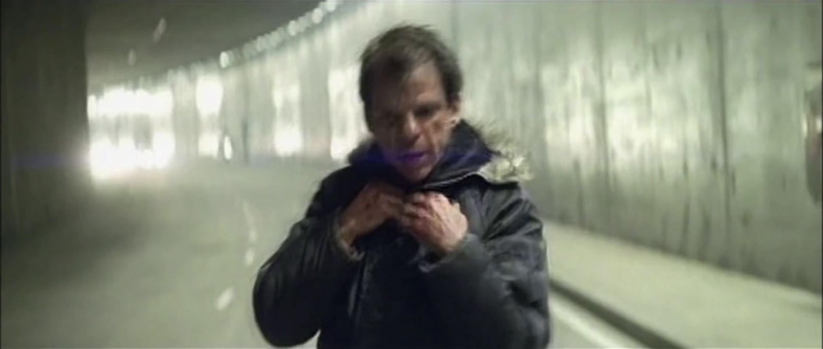 a man standing in a tunnel holding a cell phone