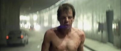 a blurry image of a shirtless man walking down a hallway