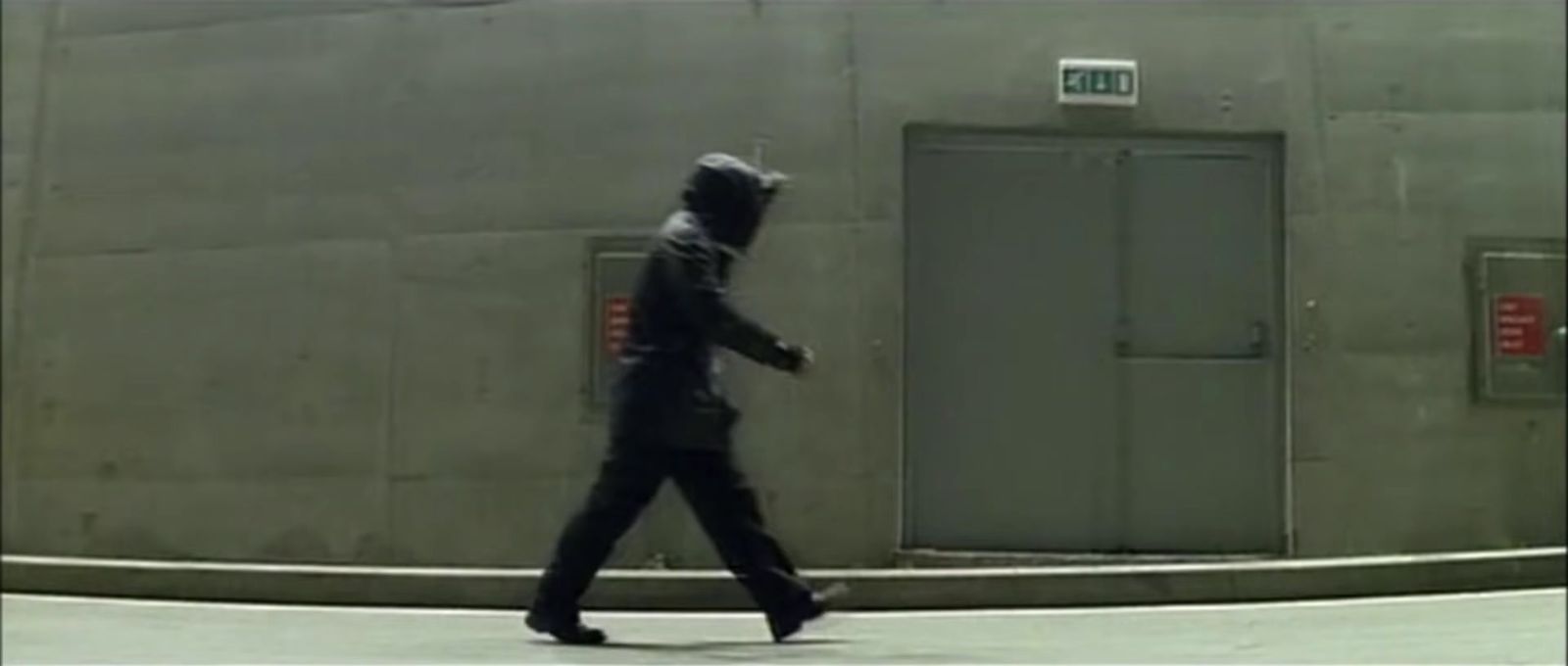 a man walking down a street past a building