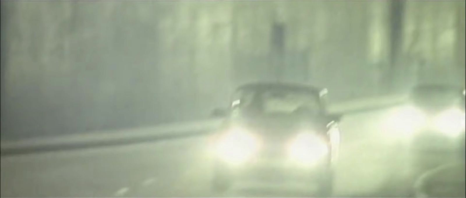 a car driving down a street in the rain