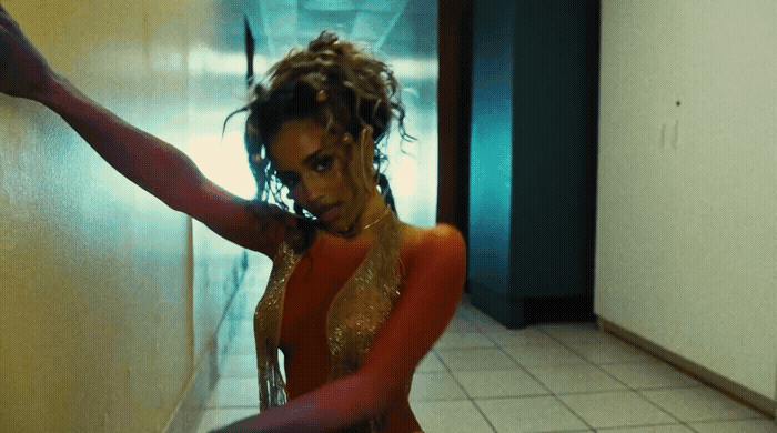 a woman in a red and gold outfit is dancing