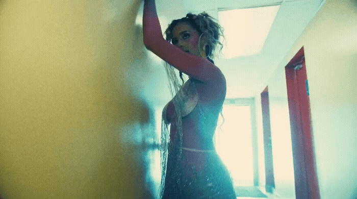 a woman in a black dress standing in a hallway