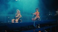 a couple of women standing on top of a stage