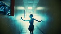 a woman standing in a hallway with her arms outstretched