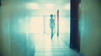 a person walking down a hallway in a building