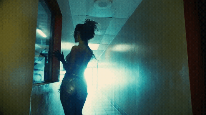 a woman standing in a hallway in a dark room