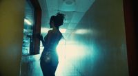 a woman standing in a hallway in a dark room