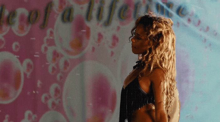 a woman standing in front of a wall with bubbles on it